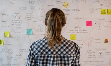 girl looking at a board with colorful sticky notes