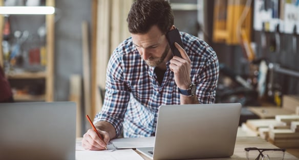 man at a computer on the phone