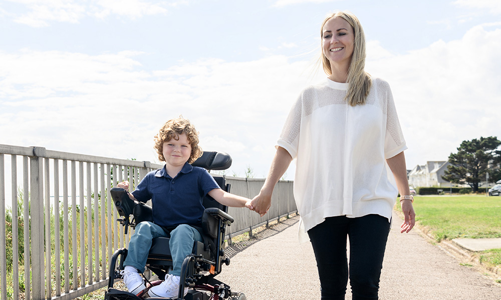 special needs planning - kid in wheel chair holding his mom's hand