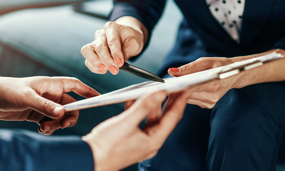 person holding a clipboard explaining documents