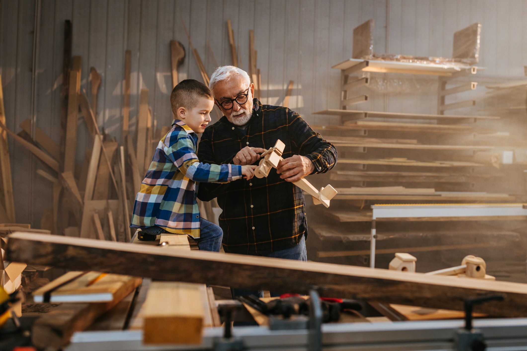 kid working in a wood shop with his grandpa 