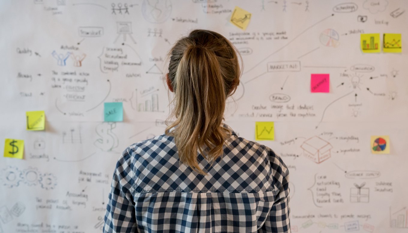 girl looking at a board with colorful sticky notes